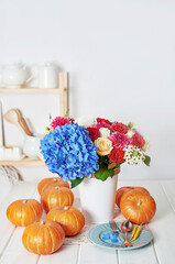 Autumn harvest pumpkin background. Pumpkins and flowers on table. Thanksgiving table. Copy space. Halloween or seasonal autumnal. Design mock up. Greeting card. Fall kitchen.