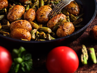 asparagus with potatoes fried in a pan with herbs