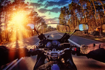motorcyclist rides the road on a sunny day