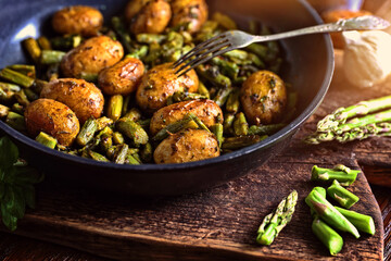 asparagus with potatoes fried in a pan with herbs - 374523084
