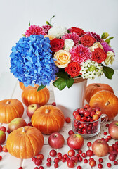 Autumn harvest pumpkin background. Pumpkins, apples and flowers on table. Thanksgiving table. Copy space. Halloween or seasonal autumnal. Design mock up. Greeting card. Fall kitchen.