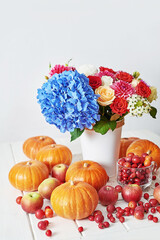 Autumn harvest pumpkin background. Pumpkins, apples and flowers on table. Thanksgiving table. Copy space. Halloween or seasonal autumnal. Design mock up. Greeting card. Fall kitchen.