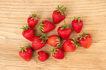 lots of fresh strawberries on a wooden table shot from above
