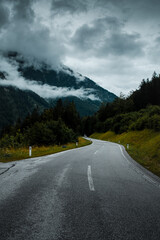 Mist and fog clouds hanging in the mountain on a rainy weather day with mountain and tree shilhouettes. Dramatic mountain view. Austrian Alps, Salzkammergut in Austria, Europe