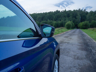 Fototapeta na wymiar Close up rear-side view of blue car in nature background
