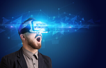 Businessman looking through Virtual Reality glasses with NETWORK OPTIMIZATION inscription, cyber security concept