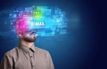 Businessman looking through Virtual Reality glasses with E-MAIL inscription, innovative security concept