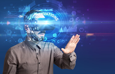 Businessman looking through Virtual Reality glasses with INNOVATIONS inscription, innovative technology concept