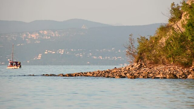 Moon bay in Slovenia at sunset. Beautiful warm colors shining on seashore. Adriatic Sea at summer. Sanctuary Famous church Monte Grisa in the distance. Static, long shot, real time