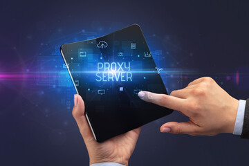 Businessman holding a foldable smartphone with PROXY SERVER inscription, cyber security concept