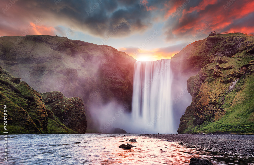 Fototapete Amazing Icelandic Landscape. Incredible view of famous Skogafoss waterfall during sunset. Dramatic Scenery of Iceland. Skogafoss Waterfall. Iceland the most beautiful and best travel place. postcard
