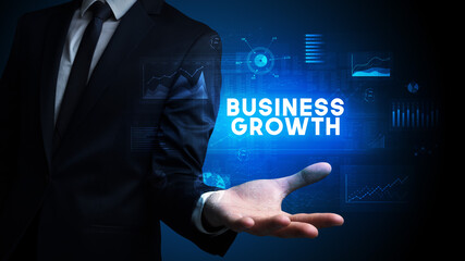 Hand of Businessman holding BUSINESS GROWTH inscription, business success concept