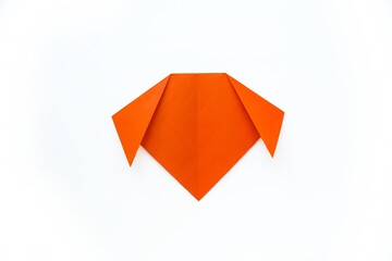 Step-by-step origami instructions. How to make a dog out of orange colored paper. Instructions on a white background top view. Step 5.