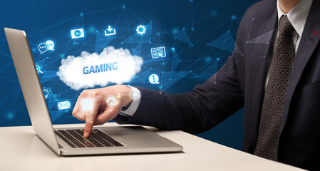 Businessman working on laptop with GAMING inscription, modern technology concept