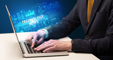 Businessman working on laptop with TECHNOLOGY NEWS inscription, cyber technology concept