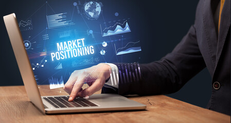 Fototapeta premium Businessman working on laptop with MARKET POSITIONING inscription, new business concept