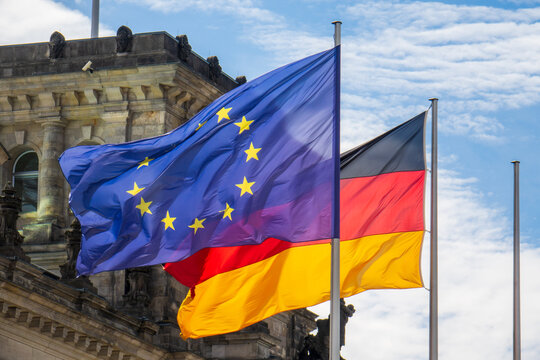 Flaggen von Deutschland und der Europäischen Union wehen im Wind vor dem Reichstag in Berlin. 