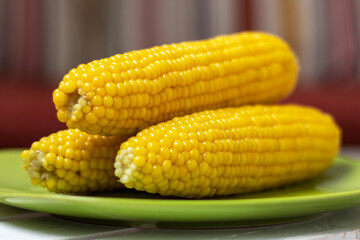 Boiled Sweetcorn On Green Plate On Wooden Table.