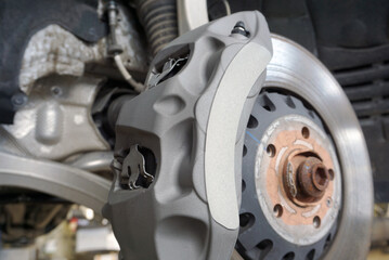 Brake caliper of a modern powerful car. The car has ventilated discs and a very large brake caliper. 