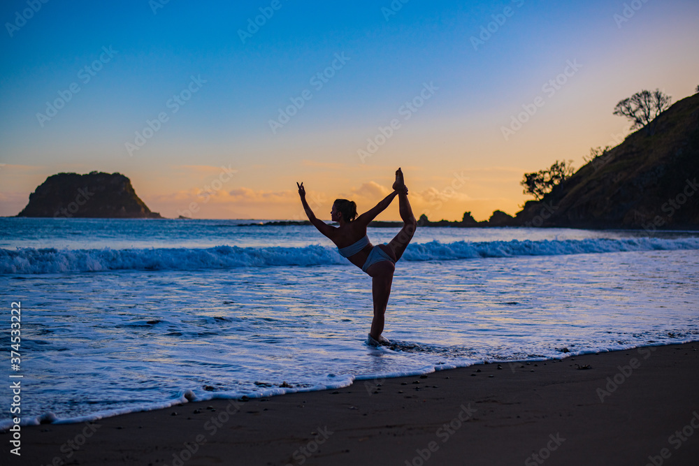 Sticker young woman doing yoga on the beach