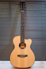 Acoustic guitar on wooden table in the room,Travel accessories concept
