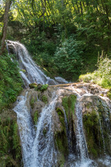 Beautiful mountain waterfall Gostilje in a green forest on natural park Zlatibor, Serbia in Europe on a sunny summer day