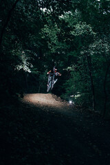 Professional mountain biker jump in forest