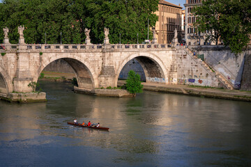  A crew team rows near a bridge on the Tiber River in Rome, Italy.