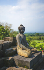 Statue of sitting buddha at Borobudur Temple, spiritual stone sculpture, UNESCO world heritage site