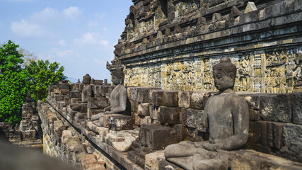Naklejka premium Statue of sitting buddha at Borobudur Temple, spiritual stone sculpture, UNESCO world heritage site