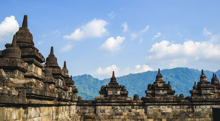 Fototapeta na wymiar Borobudur Temple in Indonesia, South East Asia, UNESCO World Heritage Site, blue sky and sunny warm weather in summer, best season to visit Indonesia, sightseeing tour