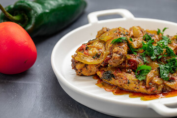 Spicy delicious chicken wings cooked with hot sauce and tomato with caramelized onions topped with chopped cilantro