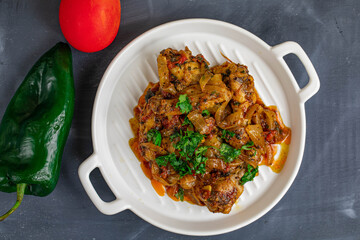 Spicy delicious chicken wings cooked with hot sauce and tomato with caramelized onions topped with chopped cilantro