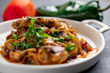 Spicy delicious chicken wings cooked with hot sauce and tomato with caramelized onions topped with chopped cilantro