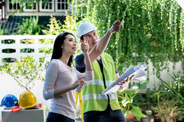 Asian attractive woman And male engineer, are looking at point and discuss about renovating the old...