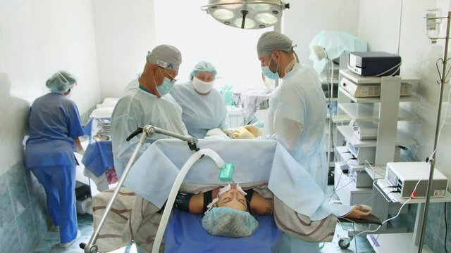 Surgeon team, in medical masks, perform surgery in hospital operating room. surgery, resuscitation or intensive care.