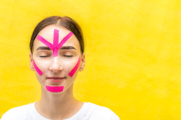 Portrait of a young woman with kinesio tapes on her face