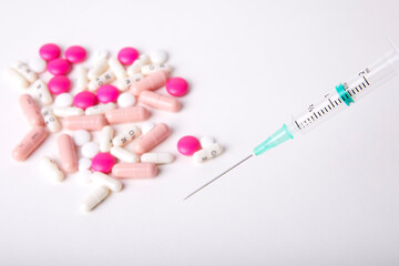 Seringue et assortiment de pillules sur fond Blanc