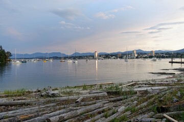 Fototapeta na wymiar A far away evening view of Nanaimo, British Columbia, Canada from the beautiful shores of Newcastle Island. A pretty cityscape view of the shoreline