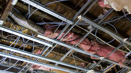 View of interior of ceiling space with ducting, wires and insulation