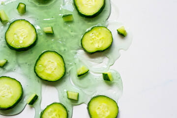 sliced cucumber pieces on a white surface with green gel