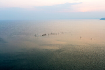 Obraz na płótnie Canvas In fog disappears fantastic beautiful seascape overlooking fishing nets and horizon near coast of Kaliakra, Bulgaria. Minimalism. Image shows nice grain pattern at 100 percent