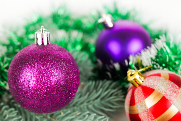 Multicolored christmas balls on a spruce branch, selective focus, bokeh