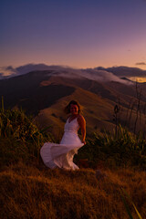 Naklejka premium woman on a mountain at sunset