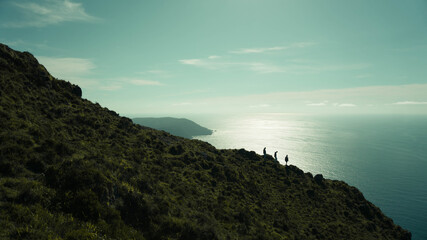 Un paisaje maravilloso de la costa gallega. Tres personas descendiendo por una ladera.