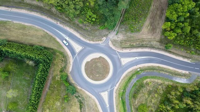 Vue a&eacute;rienne drone carrefour routier rond point avec v&eacute;hicules voitures en circulation, dans la campagne au milieu de la nature sauvage