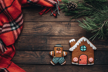 Christmas background with gingerbread cookies and fir branches on the old wooden board. 