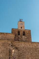 Obraz premium Clock tower with bells in a small church at Cuenca Spain with blue sky