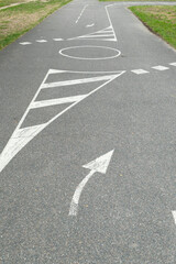 Ground marking with white paint. Driving track for bike or motorcycle. Road with direction symbol.