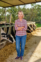 Farmer woman is working on farm with dairy cows